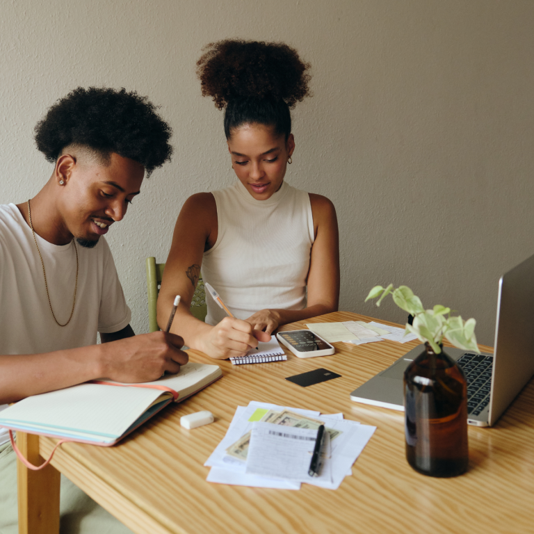 Couple working through their financial budget, identifying areas to save so they can invest.